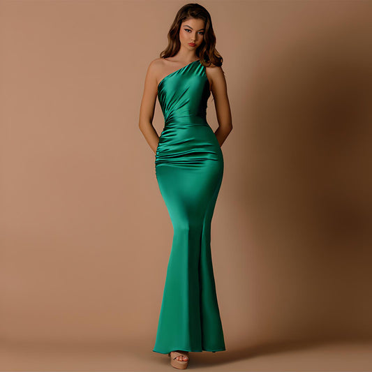 Woman wearing a green one-shoulder dress against a brown background